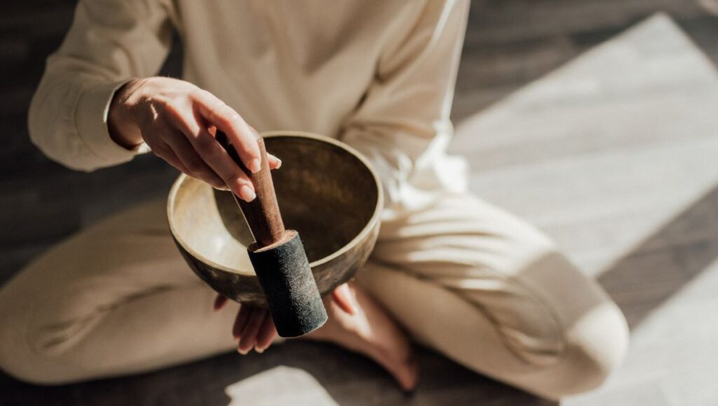 person meditating with a singing bowl 
