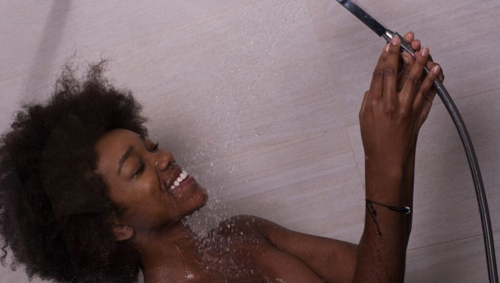 woman doing money manifestation in the shower 