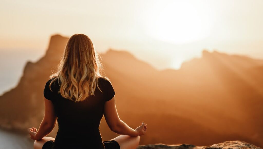 woman meditating on a mountain 